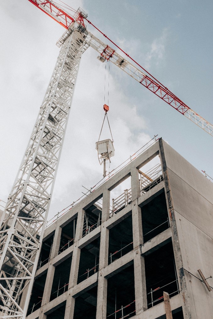 Grúa torre junto a un edificio de estructura de hormigón armado en construcción